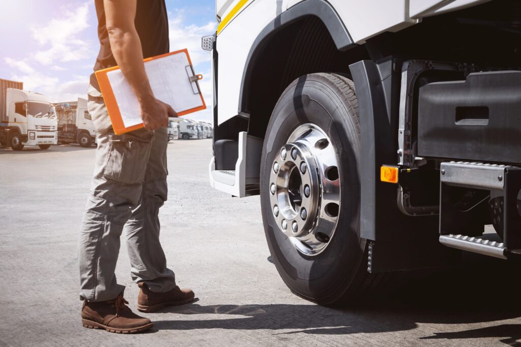 Semi truck safety inspection by mechanic with clipboard
