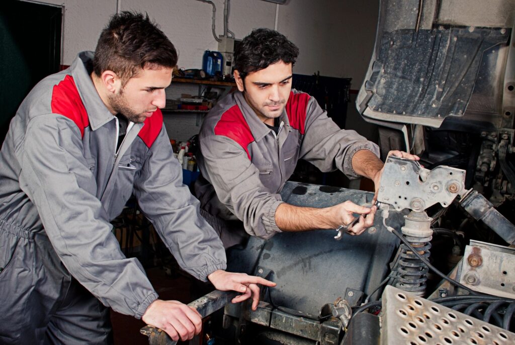 Truck mechanics performing engine repair in workshop
